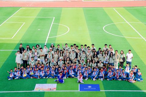 Group photo with the school on the pitch