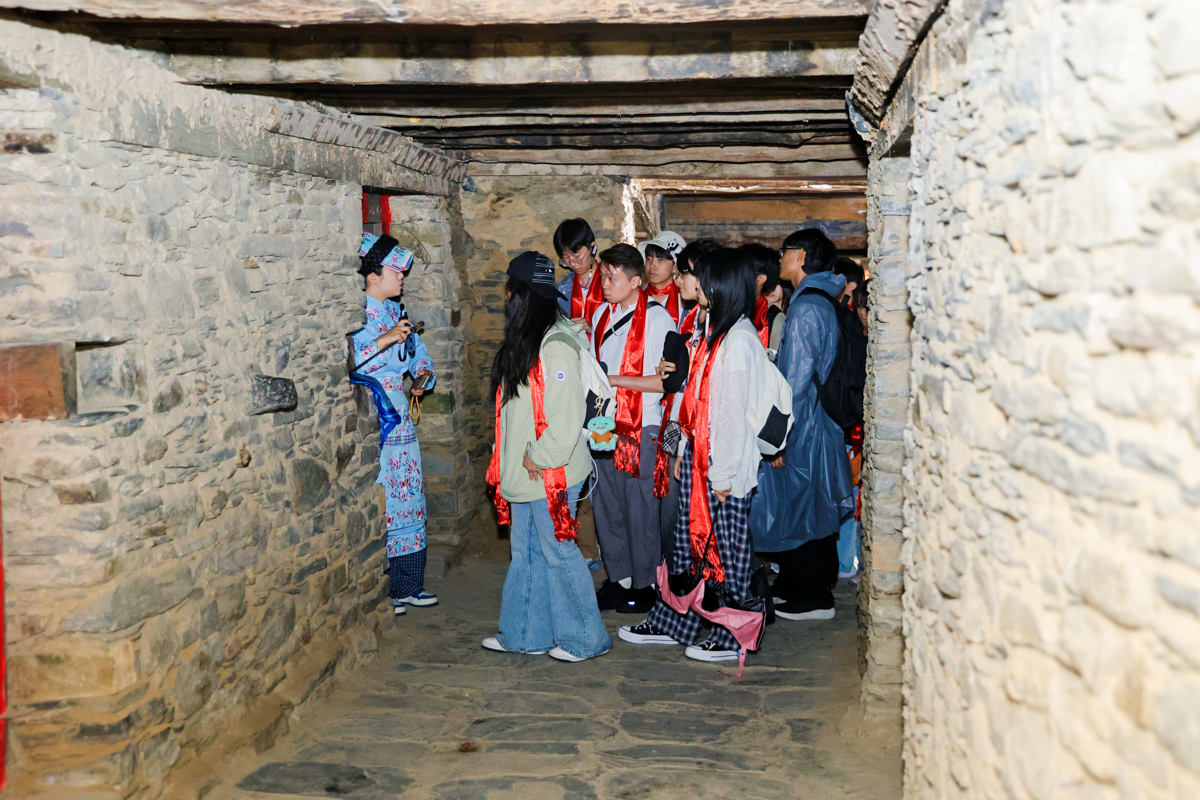 Students exploring a stone passageway in Taoping Qiang Village