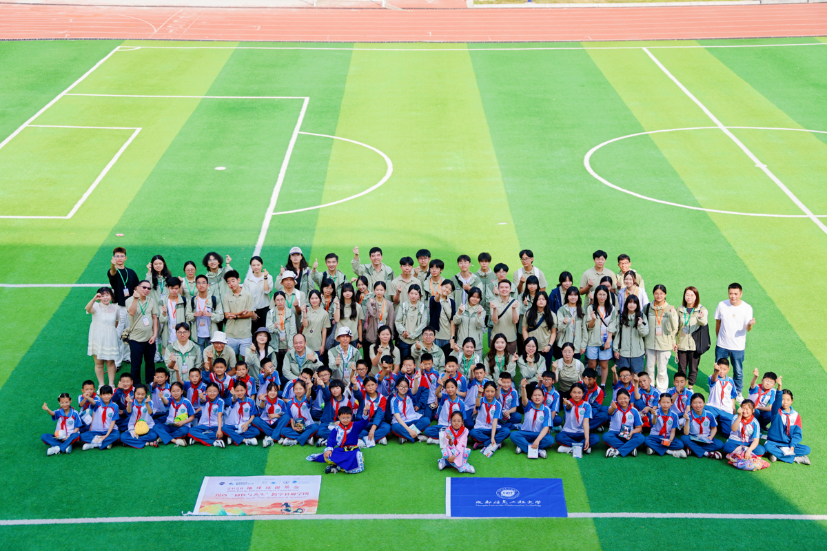Large group photo with primary school pupils on a football pitch